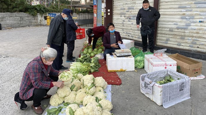 Fuzhou, Fujian, China. On February 29, 2020, vendors sold vegetables at the closed shop door. Due to the outbreak, the government closed the market.
