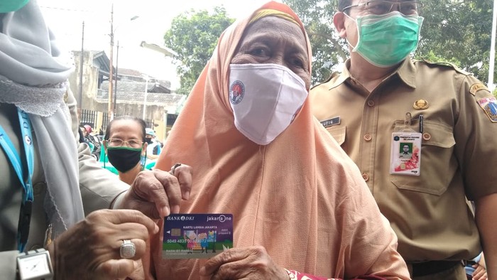 Kartu lansia DKI Jakarta Warga memperlihatkan Kartu Lansia usai penyerahan secara simbolis oleh Kepala Bidang Perlindungan dan Jaminan Sosial Dinas Sosial DKI Jakarta, Ika Yuli Rahayu yang memberikan Kartu Lansia untuk Warga Lansia di RW 12 Cengkareng Timur, Jakarta Barat, Senin (15/6/2020). Bank DKI kembali mendistribusikan Kartu Lansia Jakarta (KLJ) dan Kartu Penyandang Disabilitas Jakarta (KPDJ). Program distribusi KLJ/KPDJ dimulai Senin, 15 Juni hingga 28 Juni 2020 di 119 titik lokasi dengan 42.265 penerima manfaat.