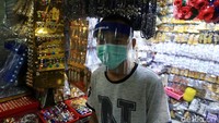 Pedagang berjualan dengan menerapkan protokol kesehatan seperti memakai masker dan face shield.