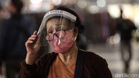 Tidak hanya pedagang, sebagian pengunjung juga memakai face shield saat mendatangi pasar tersebut.