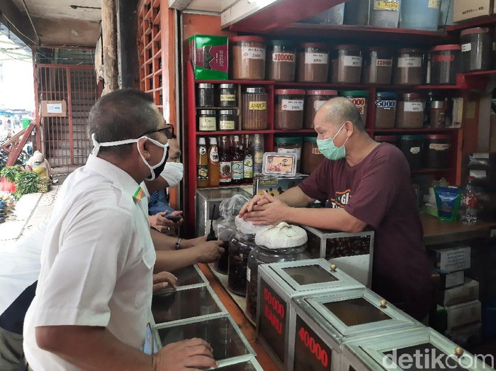 Pengelola Pasar Perumnas Klender mengecek penerapan sistem ganjil-genap pasar.