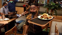 Pramusaji menyajikan menu makanan kepada pelanggan di Restoran Dapur Solo di Lippo Mall Puri, Jakarta Barat, Senin (15/6/2020).