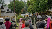 Sejumlah warga melihat proses evakuasi bangkai pesawat tempur TNI AU yang jatuh di pemukiman warga di Desa Kubang Jaya, Kabupaten Kampar, Riau, Selasa (16/6/2020). 