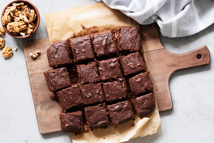 brownies Chocolate brownie squares with walnuts on cutting board, top view, horizontal composition. Flat lay food