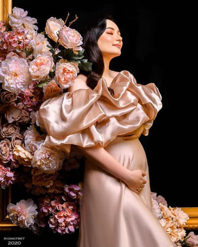 Pada foto berikutnya, Asmirandah tampil cantik berbalut gaun satin warna champagne dengan aksen ruffle. Gaun tersebut keluaran dari brand lokal Rouse Label. Foto: Instagram/@asmirandah, @riomotret