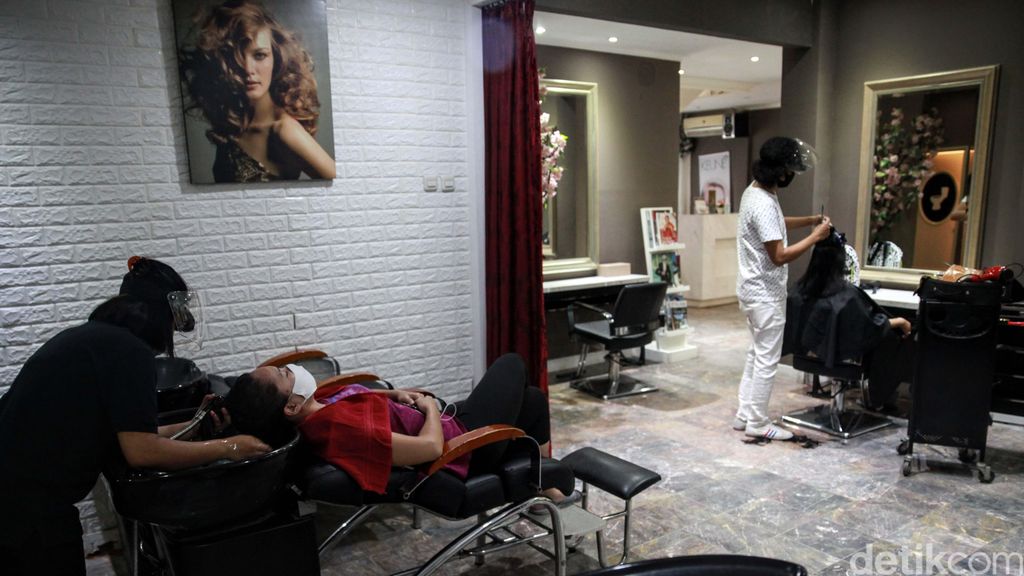 Geliat Ekonomi Usaha Kecil di Masa New Normal Hairstylist dengan memakai APD beraktivitas di salon kecantikan Guzell di Bintaro, Tangsel, Banten. Pelonggaran PSBB dimanfaatkan pelaku UKM untuk memulihkan ekonomi.