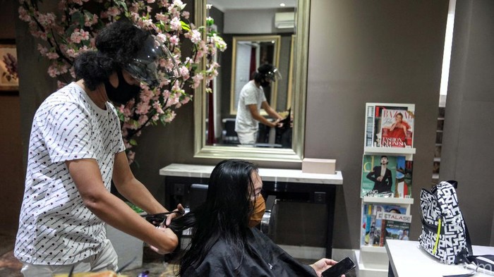 Geliat Ekonomi Usaha Kecil di Masa New Normal Hairstylist dengan memakai APD beraktivitas di salon kecantikan Guzell di Bintaro, Tangsel, Banten. Pelonggaran PSBB dimanfaatkan pelaku UKM untuk memulihkan ekonomi.