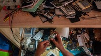 Seorang pekerja sedang memperbaiki telepon genggam pelanggan di Kampung Rumbut, Lebak, Banten, Selasa (16/6/2020).
