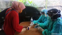 Warga yang telah selesai menjalani tes harus mencelupkan jarinya ke tinta.