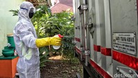 Seorang petugas menyemprotkan desinfektan dibeberapa bagian truk yang sering di sentuh.