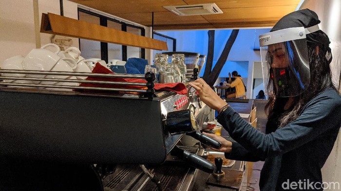 PENERAPAN NORMAL BARU DI COFFEE SHOP Barista menyajikan menu kopi di coffee shop Kopi Manyar, Bintaro, Jakarta Selatan, Selasa (16/6/2020). Coffee shop yang didesain oleh arsitek beken Andra Matin tersebut kembali melayani layanan makan di tempat (dine in) dengan menerapkan tatanan normal baru dengan menjalankan protokol kesehatan guna mencegah penularan COVID-19. Layanan dine in mulai dilakukan sejak Senin (15/6) sesuai aturan PSBB transisi pemerintah.