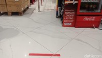 Pengunjung yang antre di kasir juga harus menjaga jarak sesuai tanda merah. 