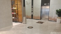 Aturan jaga jarak juga berlaku pada antrean lift. 