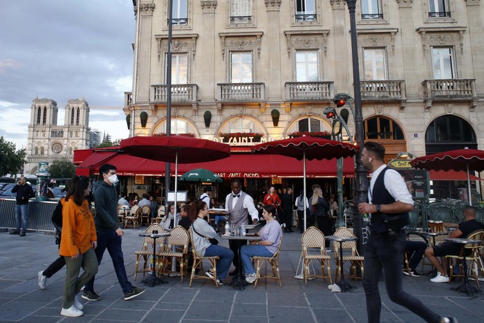 People sit on a cafe, Monday, June 15, 2020 in Paris. Paris is rediscovering itself, as its cafes and restaurants reopen for the first time since the fast-spreading virus forced them to close their doors March 14. Restaurants outside the Paris region opened earlier this month, and Paris cafes were allowed to serve people outside but not open their doors. After three months of losses, some restaurateurs fear it will take a long time for business to come back. (AP Photo/Thibault Camus)