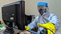 Pegawai Dinas Kependudukan dan Pencatatan Sipil dengan menggunakan pakaian alat pelindung diri (APD) lengkap melakukan perekaman data pembuatan KTP Elektronik di Kantor Kecamatan Pondok Aren, Tangerang Selatan, Banten, Selasa (16/6/2020).