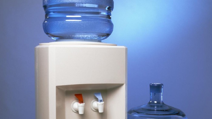 585609666 Glass being filled at a water cooler