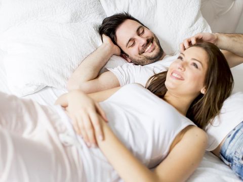 Young loving couple in bed. Happy couple relaxing in bed.