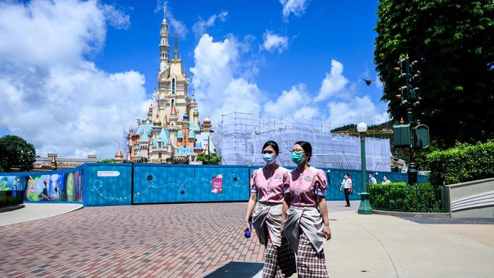Staf Disneyland Hong Kong memeriksa kawasan itu sebelum dibuka lagi mulai Kamis (18/6/2020). (Anthony WALLACE / AFP)