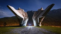 Gambar di sini ditangkap di Monumen Pertempuran Sutjeska di Bosnia dan Herzegovina, dengan cahaya bulan purnama berkilau saat menghantam beton lembab dari monumen WW2. Obor genggam digunakan untuk menerapkan beberapa highlight di sekitar sosok manusianya.  