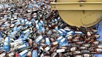 Petugas mengoperasikan alat berat untuk memusnahkan barang bukti minuman keras ilegal di Dermaga Ditpolairud Polda Kepulauan Bangka Belitung, Air Anyir, Kabupaten Bangka, Kepulauan Bangka Belitung, Rabu (17/6/2020). 
