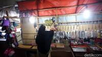 Seorang pedagang menggelar dagangan di tengah sepinya pengunjung akibat pandemi COVID-19.