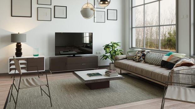 Posters on grey wall above white cupboard in bright living room interior with sofa and carpet. Real photo