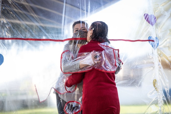GRAVATAI, BRAZIL - JUNE 16: A nurse cleans theTunel do Abraco (Hug Tunnel) at the Geriatric Clinic Três Figueiras on June 16, 2020 in Gravatai, Brazil. The clinic created the Tunel do Abraco (hug tunnel) for elderly residents to be able to hug relatives after more than 70 days apart due to the coronavirus pandemic. The tunnel is made of a thick plastic curtain with sleeves, which guarantees the safety of families. After each use, the environment is cleaned by a clinic professional. (Photo by Lucas Uebel/Getty Images)