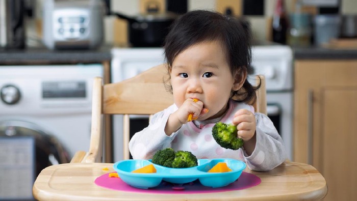 Anak makan sayur Asian baby girl eating vegetable first time at home kitchen