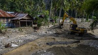 Operator alat berat membuat tanggul penahan arus air sungai di dekat pemukiman warga di Desa Omu, Sigi, Sulawesi Tengah, Kamis (18//6/2020).