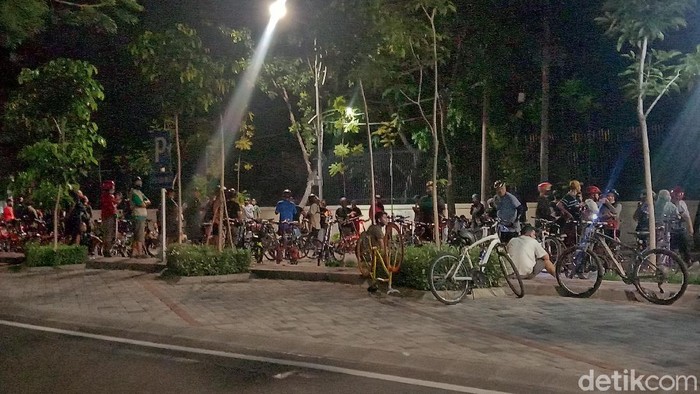 Ratusan pesepeda malam berkumpul di area SMA Komplek Surabaya, Jalan Wijaya Kusuma. Mereka asyik berfoto hingga lupa menjaga jarak atau physical distancing