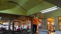 Petugas membersihkan langit-langit bangunan pasar saat pasar ditutup.