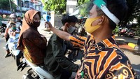 Pengecekan suhu tubuh juga diterapkan oleh petugas pengamanan di depan gerbang, sebelum masuk ke sekolah.