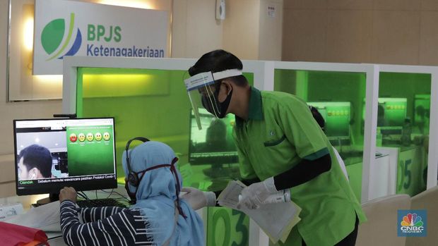 Peserta BP Jamsostek konsultasi layanan tanpa kontak fisik dengan virtual di Kantor Cabang BPJS Ketenagakerjaan Cilandak, Kamis (18/6/2020). Layanan secara virtual ini merupakan penerapan sesuai dengan protokol kesehatan tanpa harus kontak langsung antara petugas dan peserta BP Jamsostek dalam rangka mencegah penularan COVID-19. Kepala Kantor Cabang Puspitaningsih mengatakan adanya layanan konsultasi tanpa kontak fisik ini di Cabang Cilandak ini disesuaikan dengan aturan protokol kesehatan dan untuk memutus penyebaran Covid-19.  Kantor cabang ini menyediakan skat-skat yang dilengkapi layar monitor yang terhubung dengan petugas secara video conference untuk kebutuhan komunikasi dan verifikasi data. 