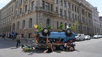 Mobil terbalik tersebut diletakkan para demonstran di persimpangan jalan yang berada di dekat German Association of teh Automotive Industry (VDA).
