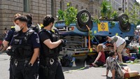 Sejumlah petugas kepolisian bersiaga di depan sebuah mobil terbalik yang dibawa para demonstran dalam aksi unjuk rasa yang digelar di kawasan Berlin, Jerman, Rabu (17/6/2020) waktu setempat.