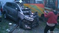 Kaca mobil juga pecah dan kap mobil juga tampak terlepas.