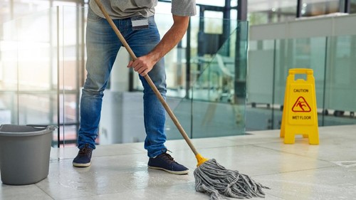 Shot of an unrecognizable man mopping the office floor