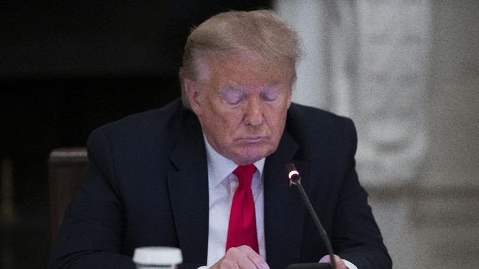 President Donald Trump looks at his phone during a roundtable with governors on the reopening of Americas small businesses, in the State Dining Room of the White House, Thursday, June 18, 2020, in Washington. (AP Photo/Alex Brandon)