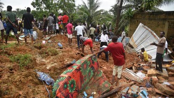 People search for survivors and bodies on the site of a landslide that killed 13 people on June 18, 2020 in Anyama, near Abidjan. - Thirteen people died and several others were missing in a landslide Thursday in a suburb of Ivory Coasts main city Abidjan after a drainage channel burst following torrential rains. (Photo by SIA KAMBOU / AFP)