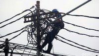 Sejumlah pekerja sedang merapikan jaringan kabel di kawasan Kebayoran Lama, Jakarta Selatan