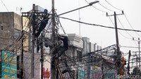 Kabel-kabel itu melintang tak beraturan dari satu tiang ke tiang lainnya.