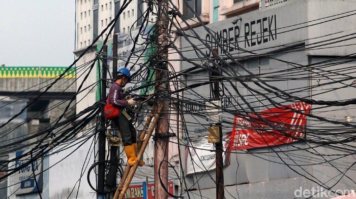Kabel Semrawut di Kebayoran Lama Para pekerja menyelesaikan instalasi jaringan kabel fiber optik di Kebayoran, Jakarta, Kamis (18/6/2020).