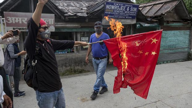 Tenzin Tsundue, an exile Tibetan activist burns a Chinese national flag during a one-man protest in Dharmsala, India, Thursday, June 18, 2020. Tsundue, said he was burning the flag as a symbolic protest against Chinese invasion of Indian territory and its continued occupation of Tibet. Twenty Indian troops were killed in a clash with Chinese soldiers in the Galwan Valley area Monday night that was the deadliest conflict between the sides in 45 years. (AP Photo/Ashwini Bhatia)
