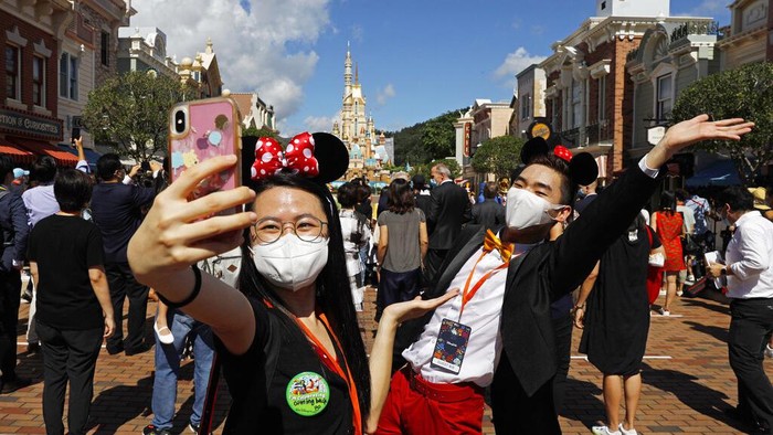 The iconic cartoon character Minnie Mouse waves to visitors at the Hong Kong Disneyland on Thursday, June 18, 2020. Hong Kong Disneyland on Thursday opened its doors to visitors for the first time in nearly five months, at a reduced capacity and with social distancing measures in place. The theme park closed temporarily at the end of January due to the coronavirus outbreak, and is the second Disney-themed park to re-open worldwide, after Shanghai Disneyland. (AP Photo/Kin Cheung)