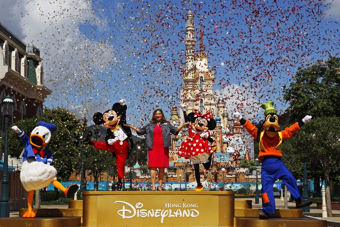 The iconic cartoon character Minnie Mouse waves to visitors at the Hong Kong Disneyland on Thursday, June 18, 2020. Hong Kong Disneyland on Thursday opened its doors to visitors for the first time in nearly five months, at a reduced capacity and with social distancing measures in place. The theme park closed temporarily at the end of January due to the coronavirus outbreak, and is the second Disney-themed park to re-open worldwide, after Shanghai Disneyland. (AP Photo/Kin Cheung)