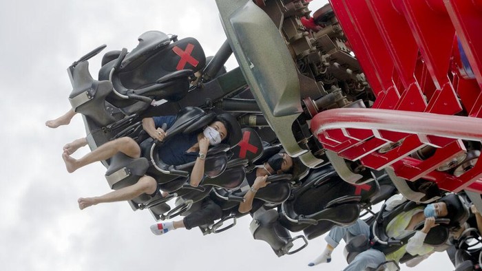 Visitors wear their face masks to help curb the spread of the coronavirus, as they ride the Vortex rollercoaster at the recently reopened Siam Amazing Park in in Bangkok, Thailand, Wednesday, June 17, 2020. Daily life in the capital resumes to norm