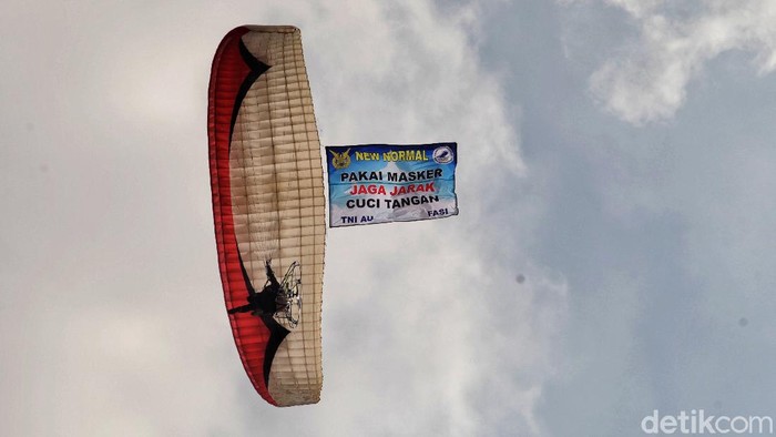 Aksi Paramotor Kampanyekan Semangat Melawan COVID-19 Pasukan TNI AU dan FASI (Federasi Aero Sport Indonesia) melakukan atraksi kampanye melawan Corona dengan paramotor di kawasan Pantai Ancol, Jakut.