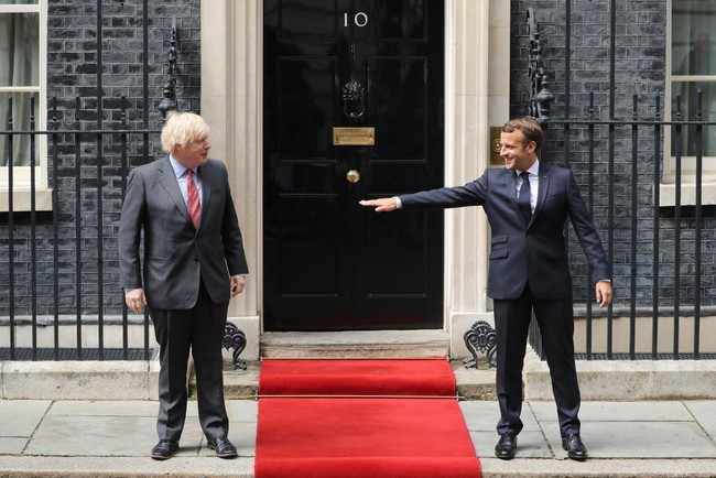 Usai meninggalkan Clarence House, Emmanuel Macron langsung menuju ke 10 Downing Street, kediaman Perdana Menteri Inggris Boris Johnson. Mereka pun berfoto di depan gedung sambil tetap menjaga jarak. Foto: Getty Images/Dan Kitwood