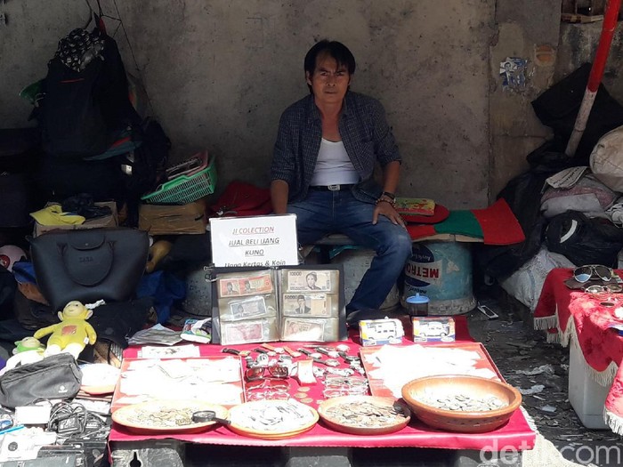 Penjual uang kuno di pasar loak Jatinegara, Jakarta.