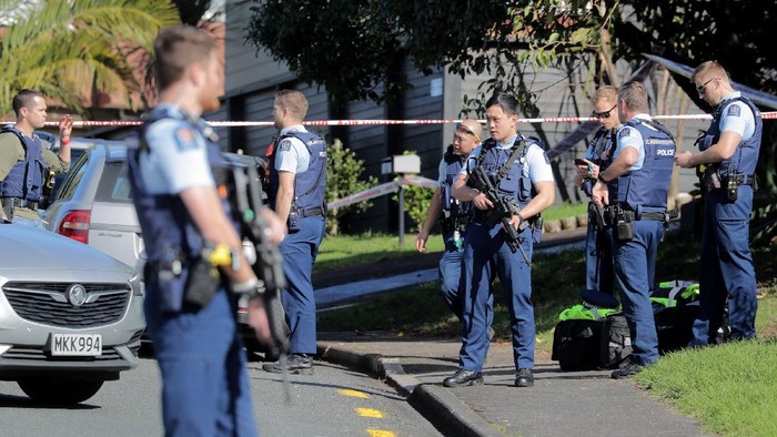 Armed police gather at the scene of a shooting incident following a routine traffic stop in Auckland, New Zealand, Friday, June 19, 2020. New Zealand police say a few officers have been shot and seriously injured and a suspect is on the run. (Michael Craig/New Zealand Herald via AP)